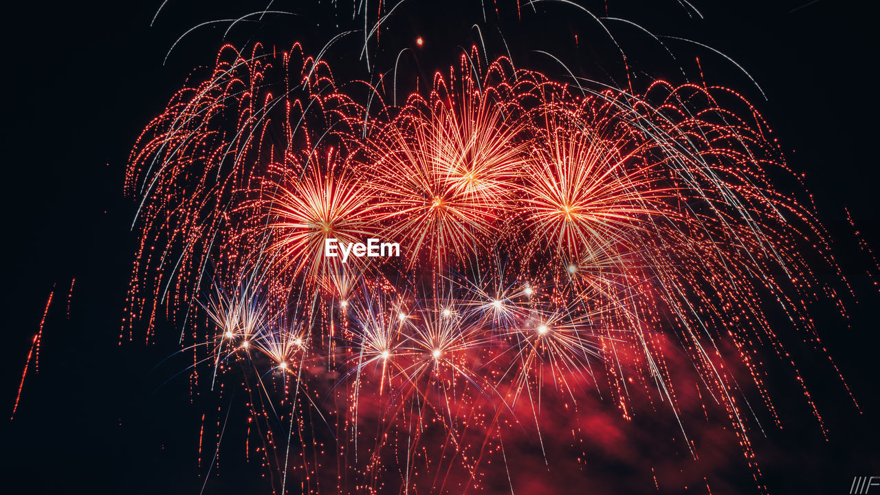 Low angle view of firework display at night