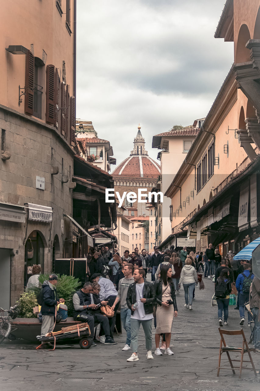 PEOPLE WALKING ON STREET BY BUILDINGS IN CITY