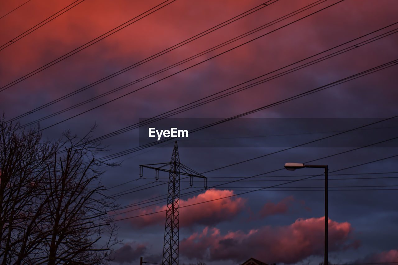 LOW ANGLE VIEW OF POWER CABLES AGAINST SKY AT SUNSET