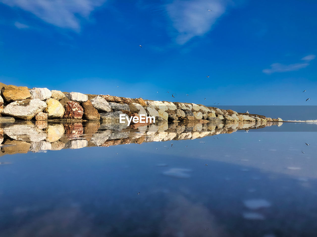 Reflection of clouds in water against blue sky