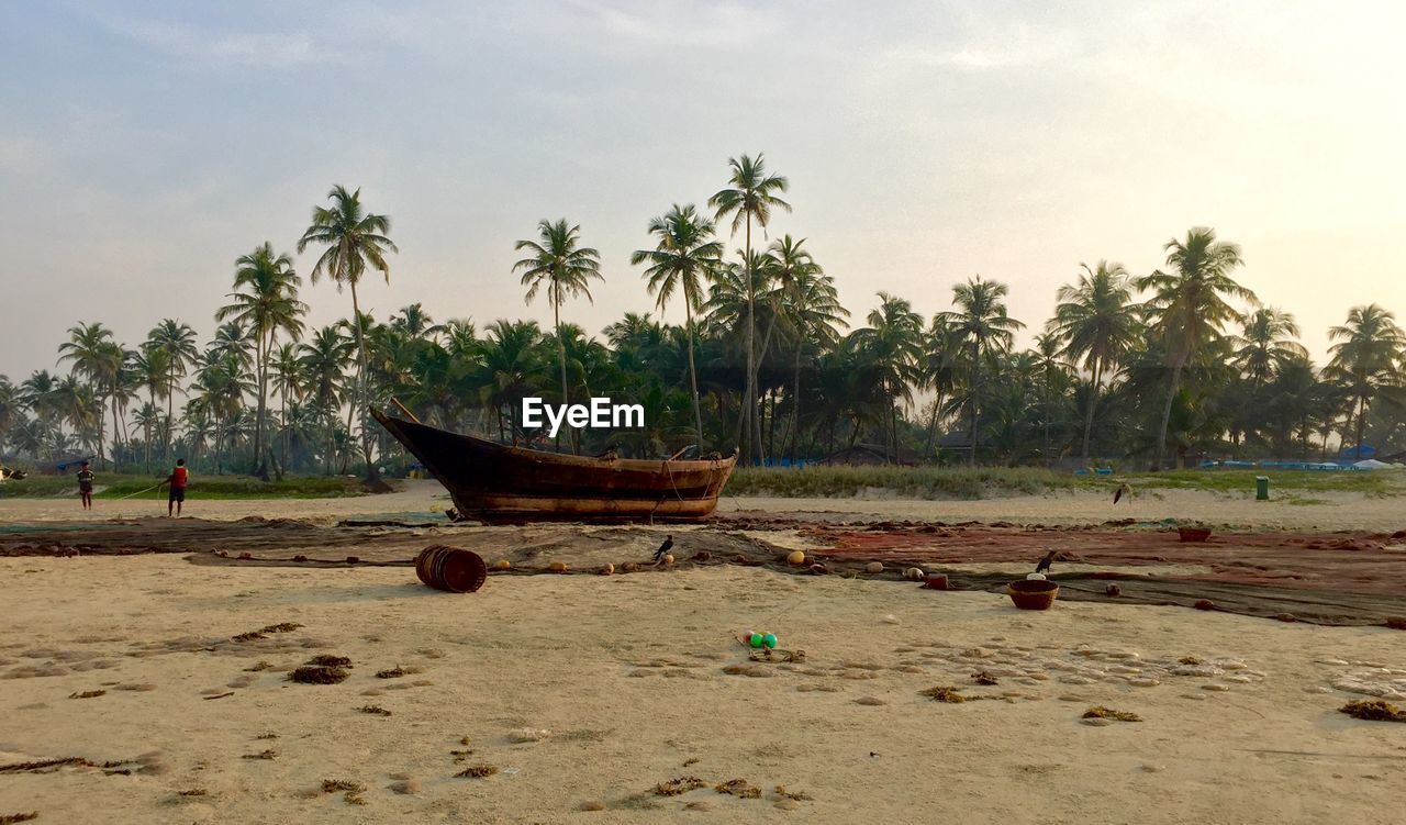 Boat moored at beach against sky