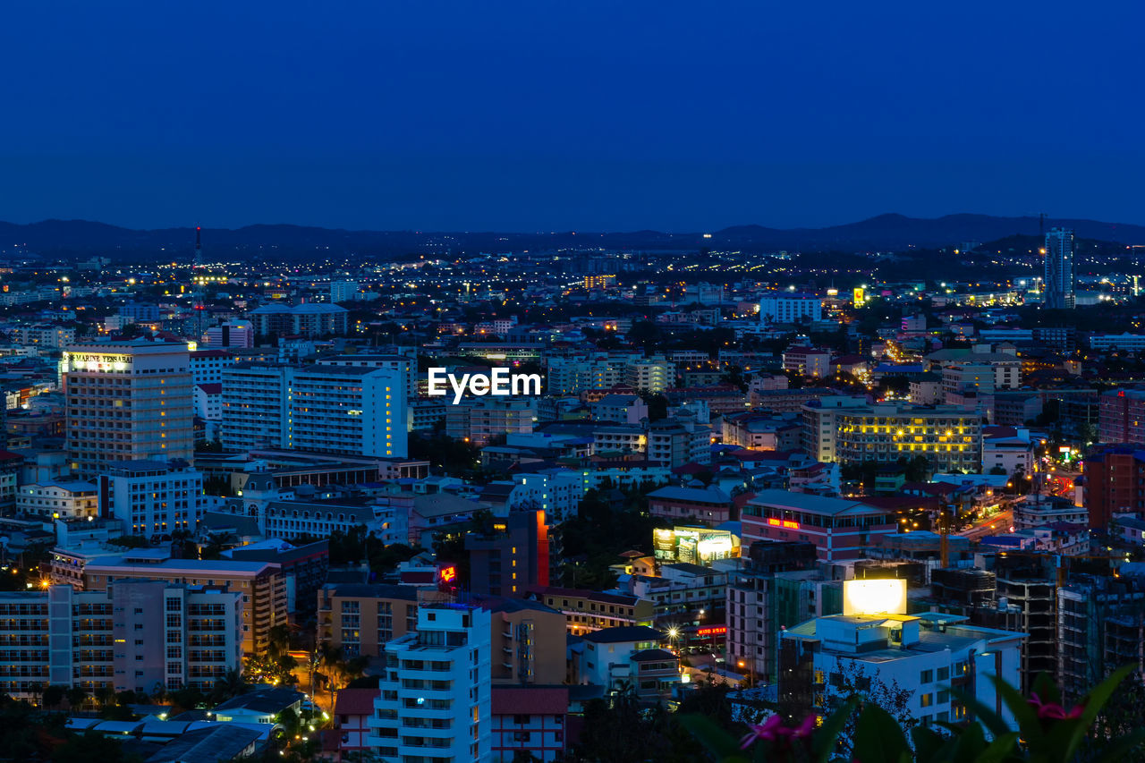 High angle view of illuminated city against clear sky at dusk