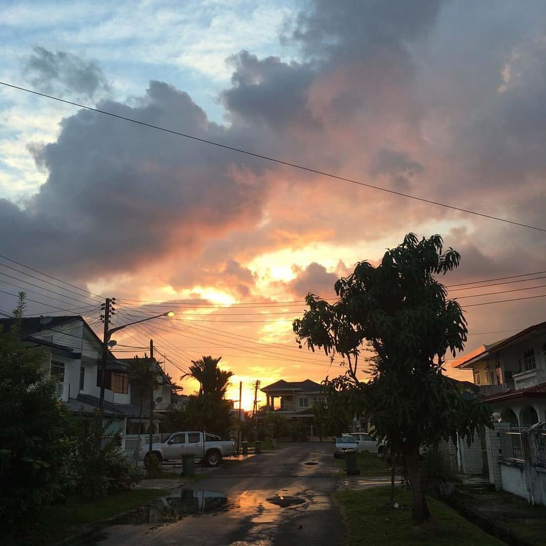 SILHOUETTE OF CITY STREET AGAINST CLOUDY SKY AT DUSK