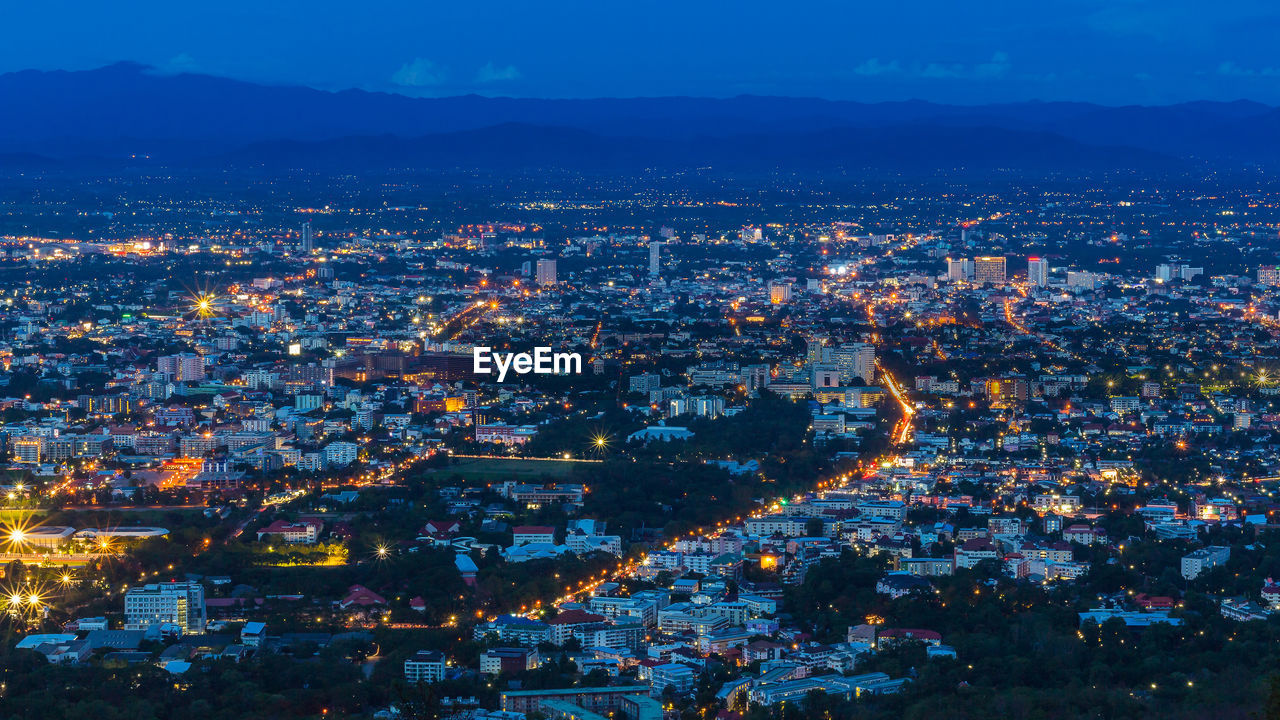 High angle view of illuminated city against sky at dusk