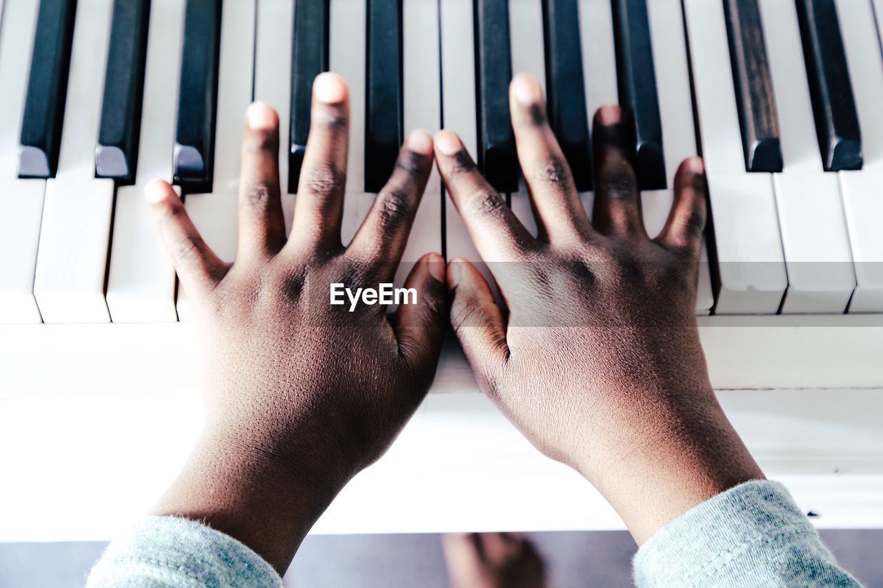 Cropped hand of child playing piano