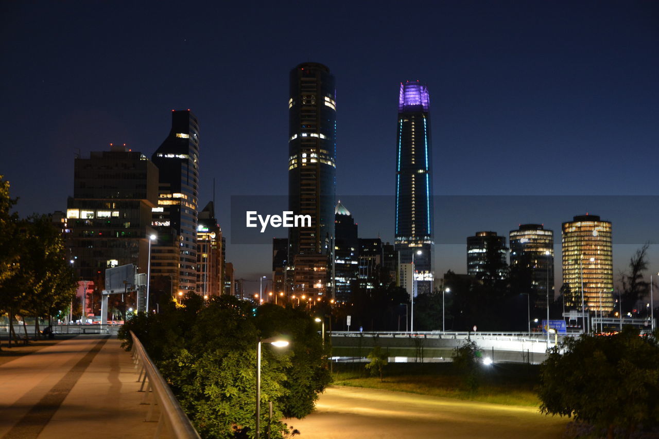 Illuminated city against clear sky at night