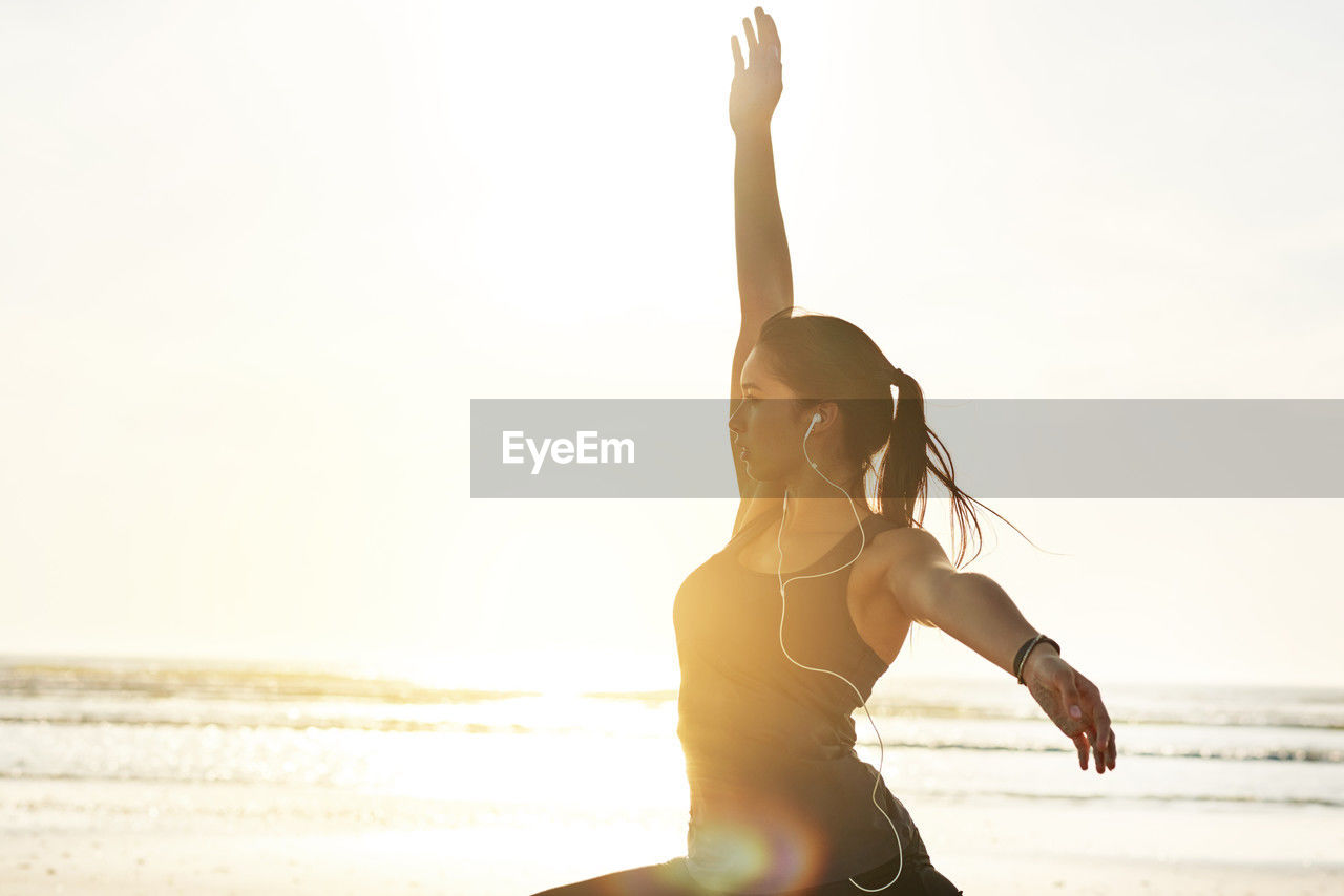 adult, one person, exercising, women, physical fitness, lifestyles, sports, wellbeing, water, land, nature, sky, stretching, yoga, sea, relaxation, young adult, beach, vitality, sunlight, arm, copy space, clothing, meditating, zen-like, spirituality, leisure activity, limb, female, flexibility, summer, sports clothing, tranquility, arms raised, beauty in nature, human limb, sitting, motion, sunset, outdoors, tranquil scene, religion, sports training, back lit, athlete, holiday, vacation, trip, sun, balance, posture, strength, activity, hairstyle, muscular build, horizon over water, recreation, photo shoot