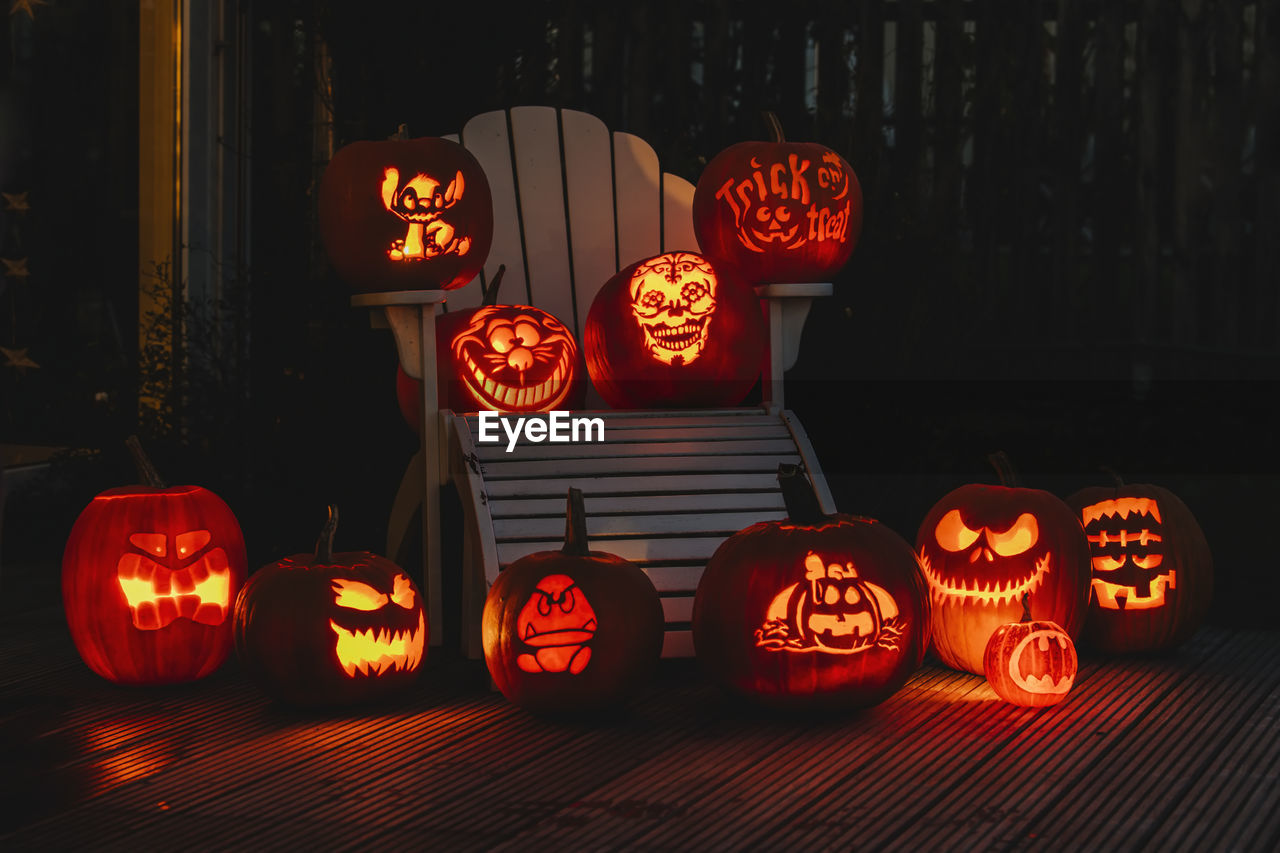 VIEW OF ILLUMINATED PUMPKINS AGAINST ORANGE WALL