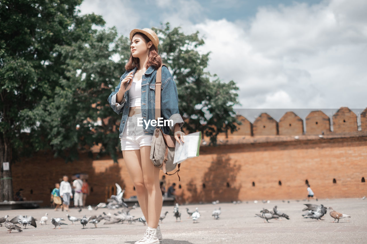 WOMAN LOOKING AWAY AGAINST TREES