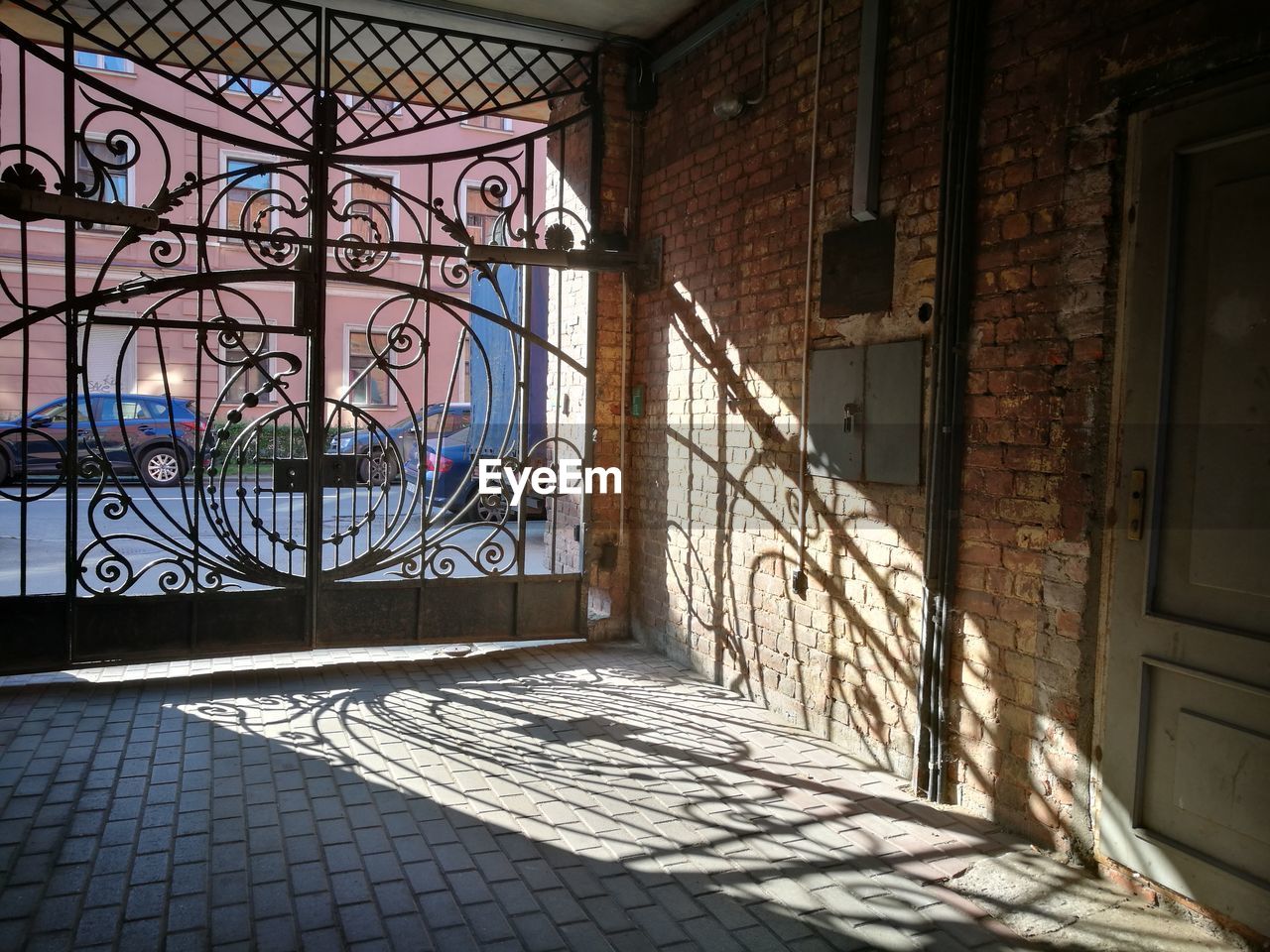 Sunlight falls to the ground through the lattice, creating a pattern of shadows.