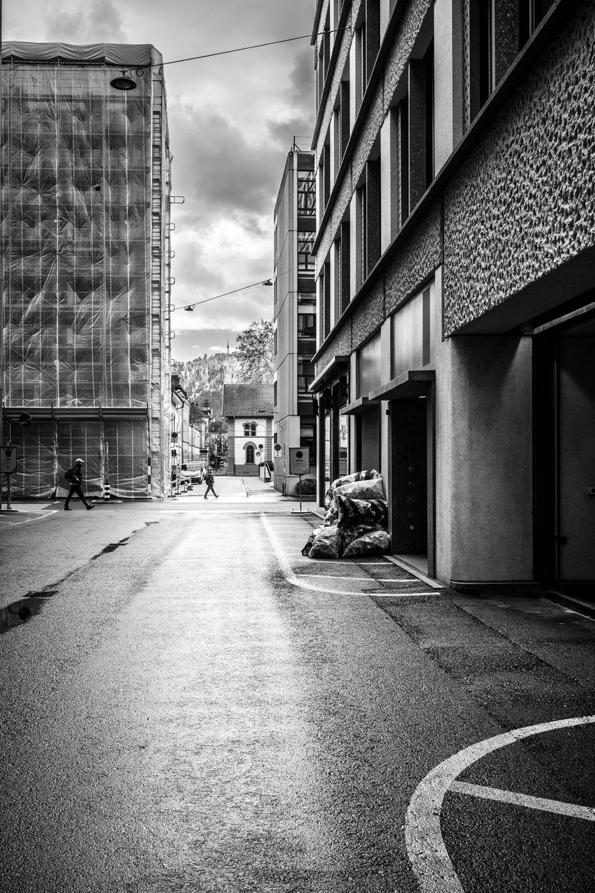 ROAD AMIDST BUILDINGS IN CITY AGAINST SKY