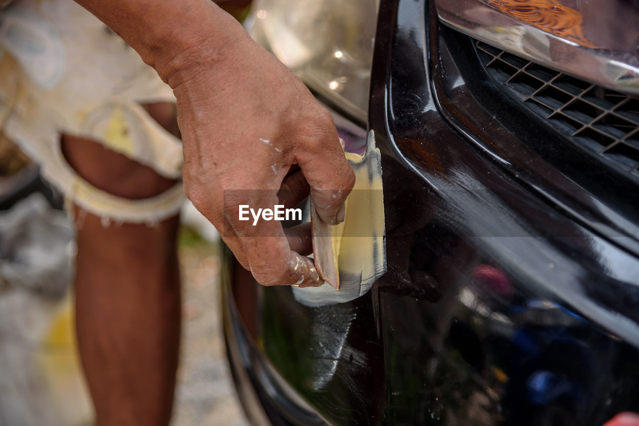 CLOSE-UP OF MAN HAND HOLDING CIGARETTE