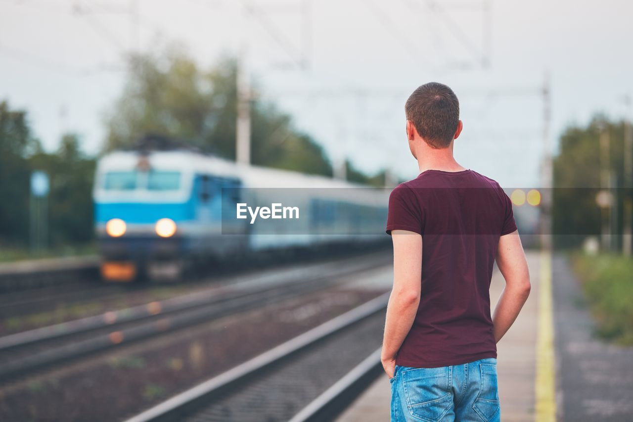 Rear view of man waiting in the railway station