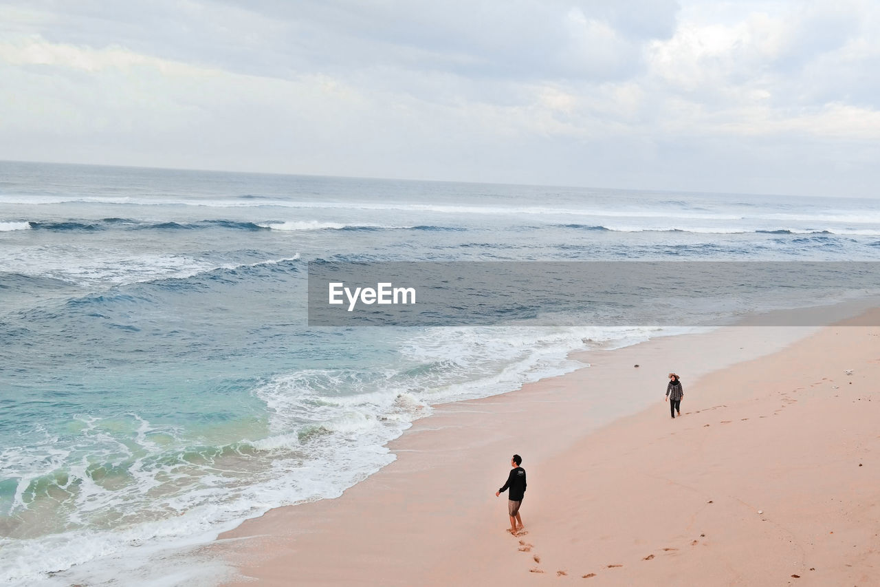 People on beach against sky