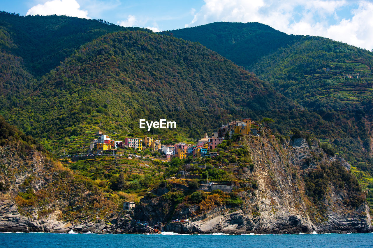 Scenic view of sea by mountains against sky