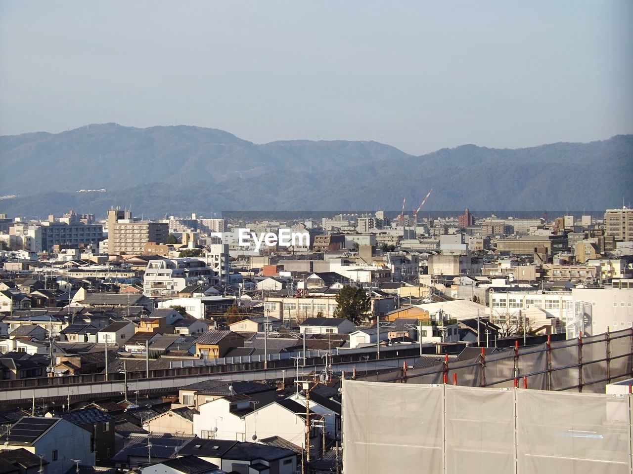 HIGH ANGLE VIEW OF TOWN IN CITY AGAINST SKY