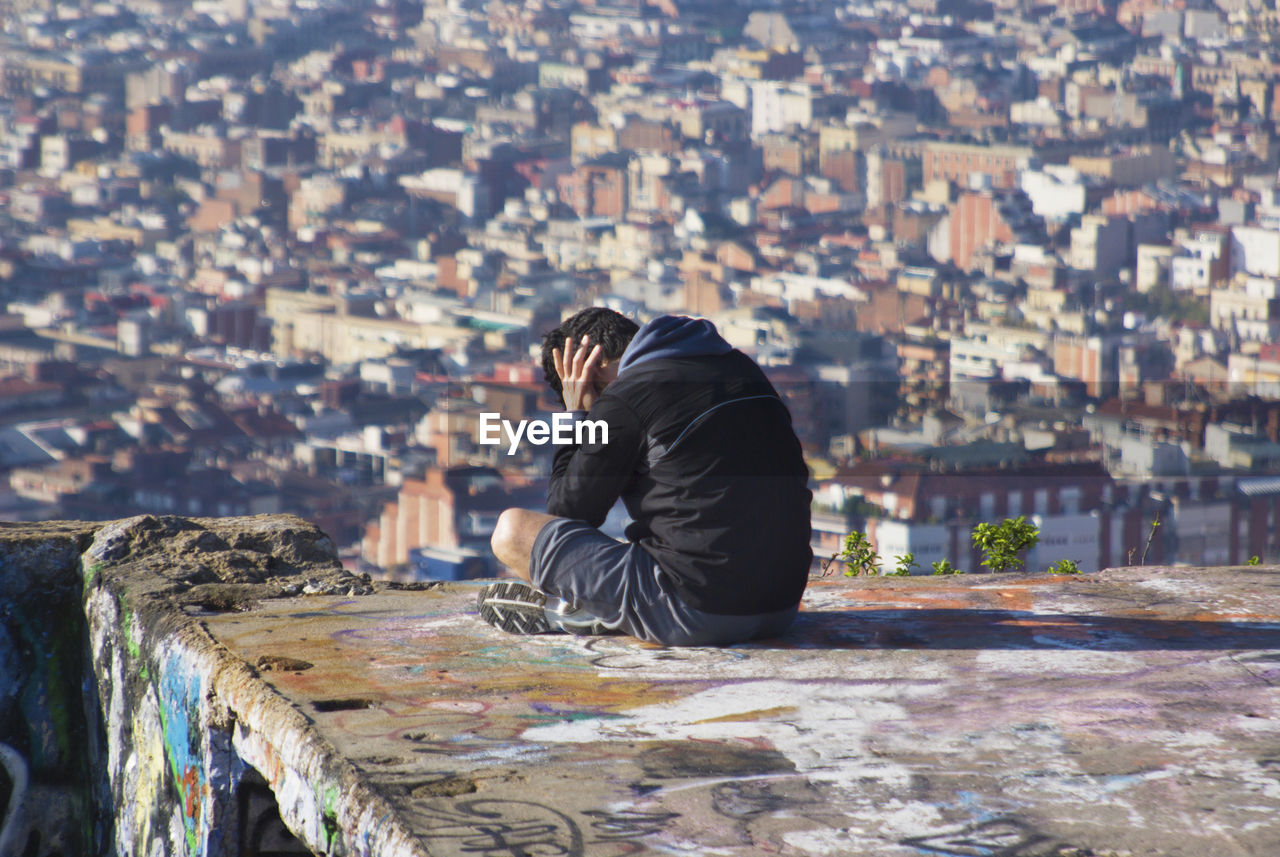 Tensed mature man sitting on terrace in city