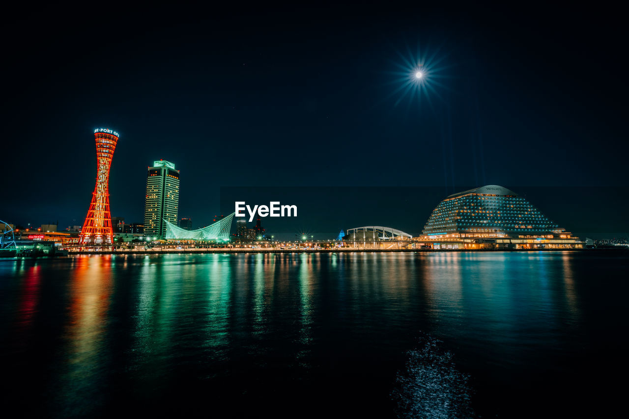 ILLUMINATED CITY SKYLINE AGAINST SKY AT NIGHT