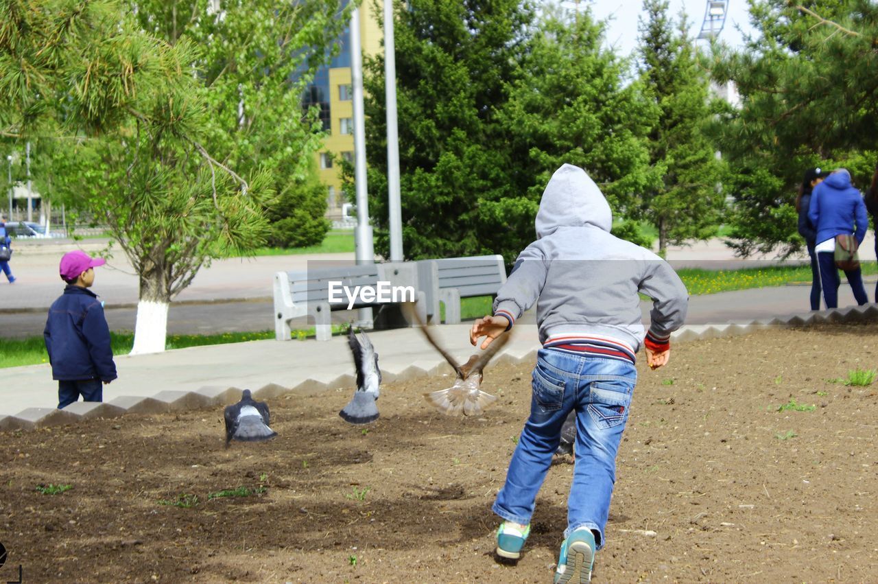 Rear view of boy playing at park