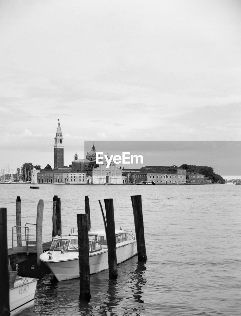 WOODEN POSTS IN SEA AGAINST BUILDING