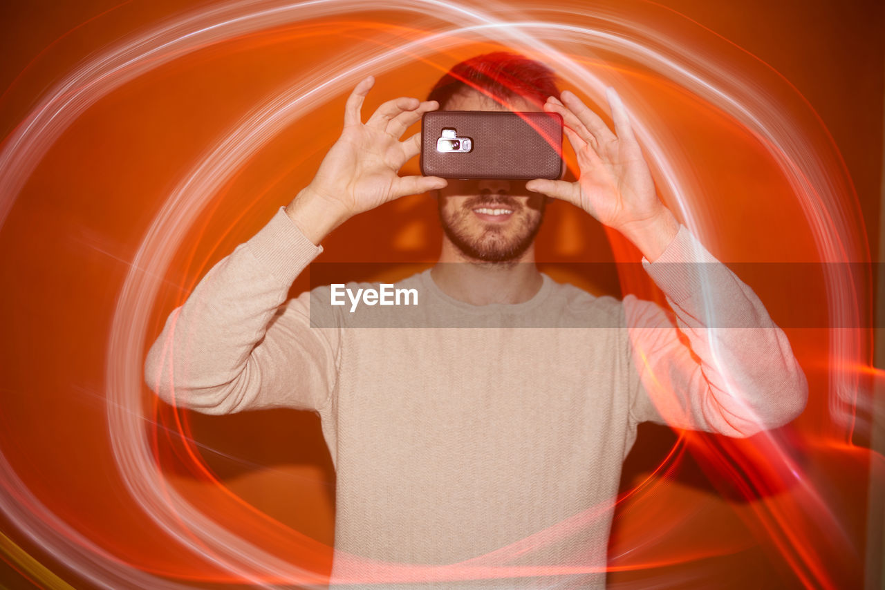 Young man with smartphone and flashes of colored light