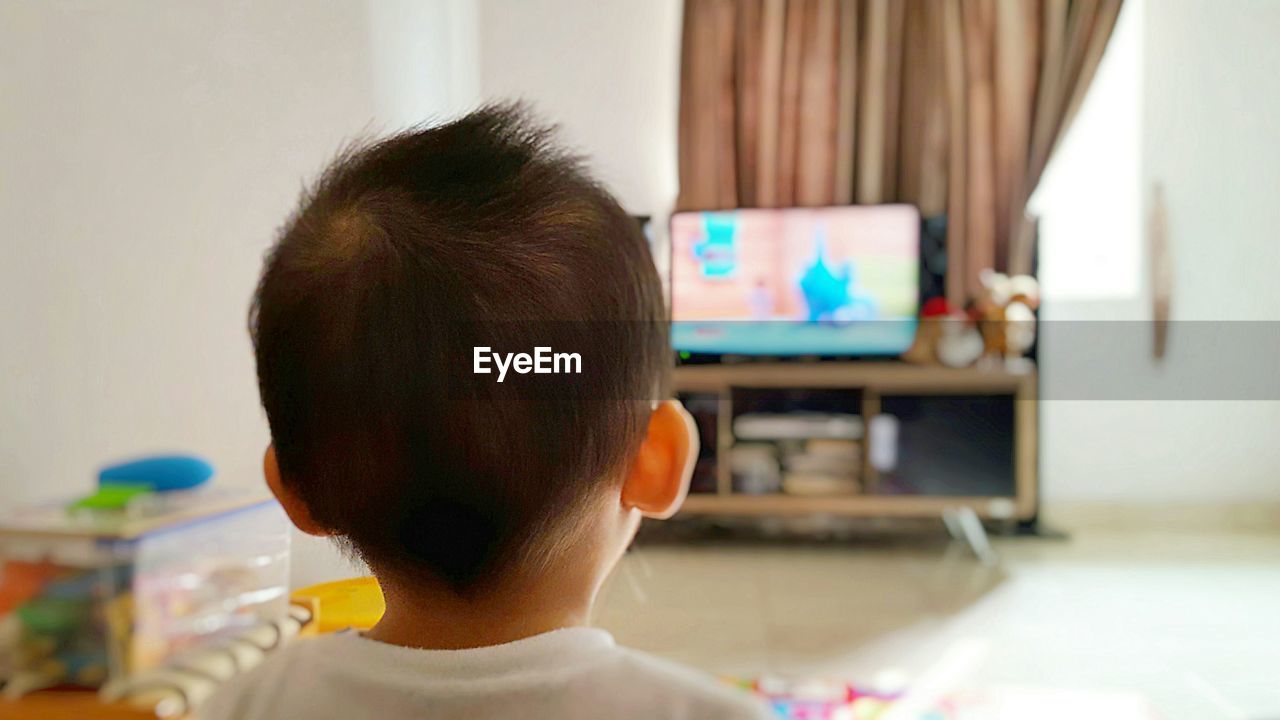 Close-up of young boy watching tv