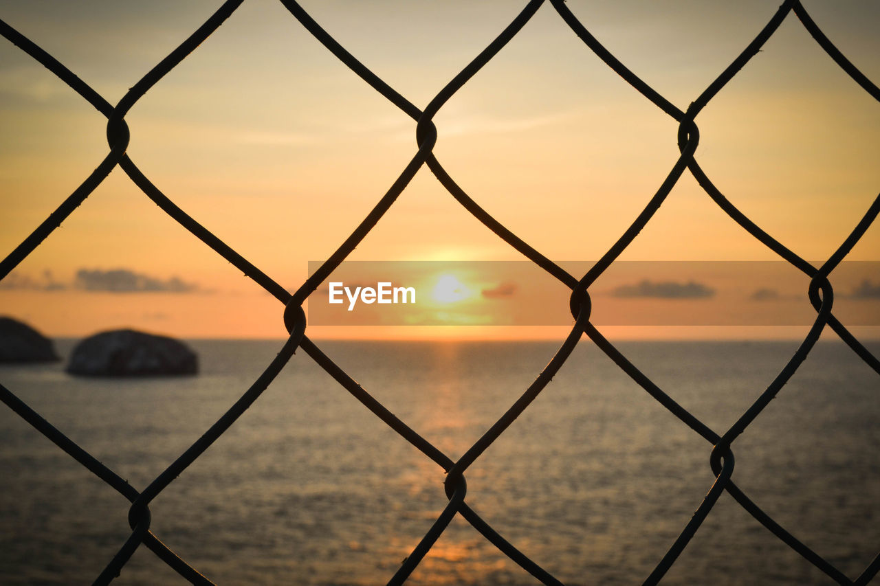 View of chain link fence at sunset