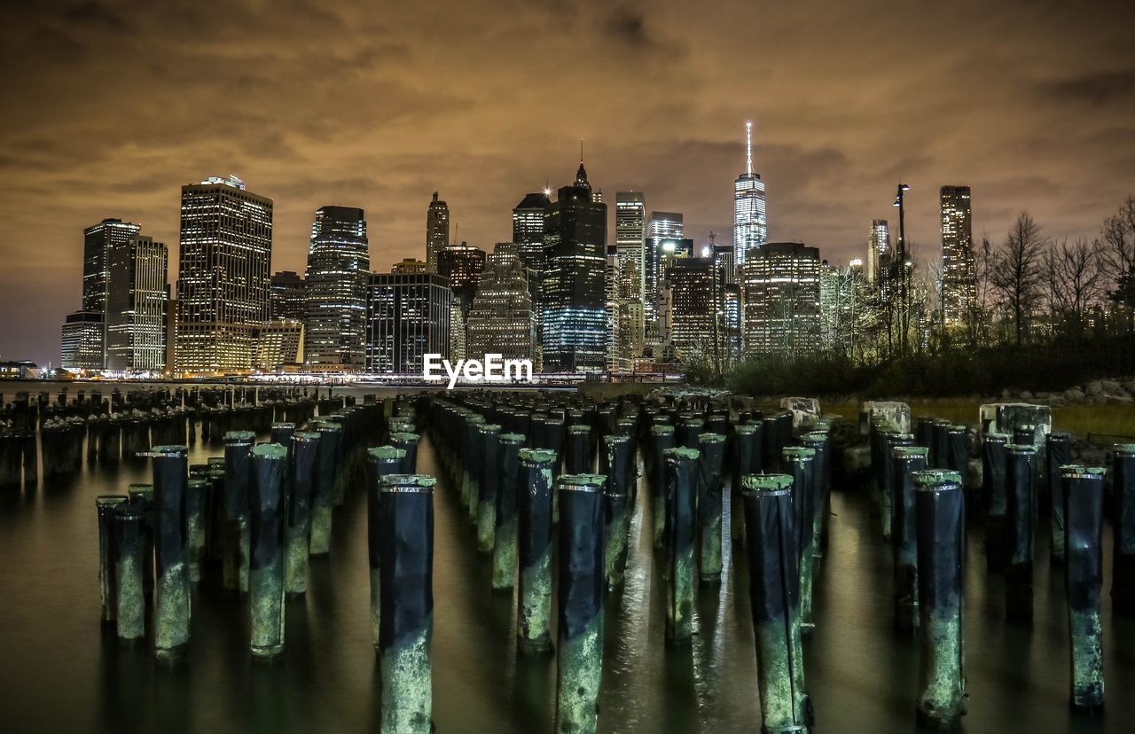 View of illuminated city against cloudy sky