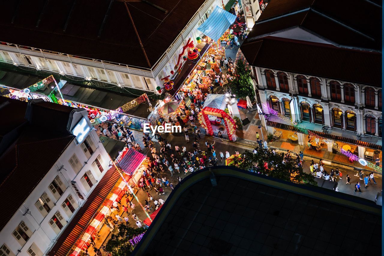 High angle view of crowd on street amidst buildings in city at night