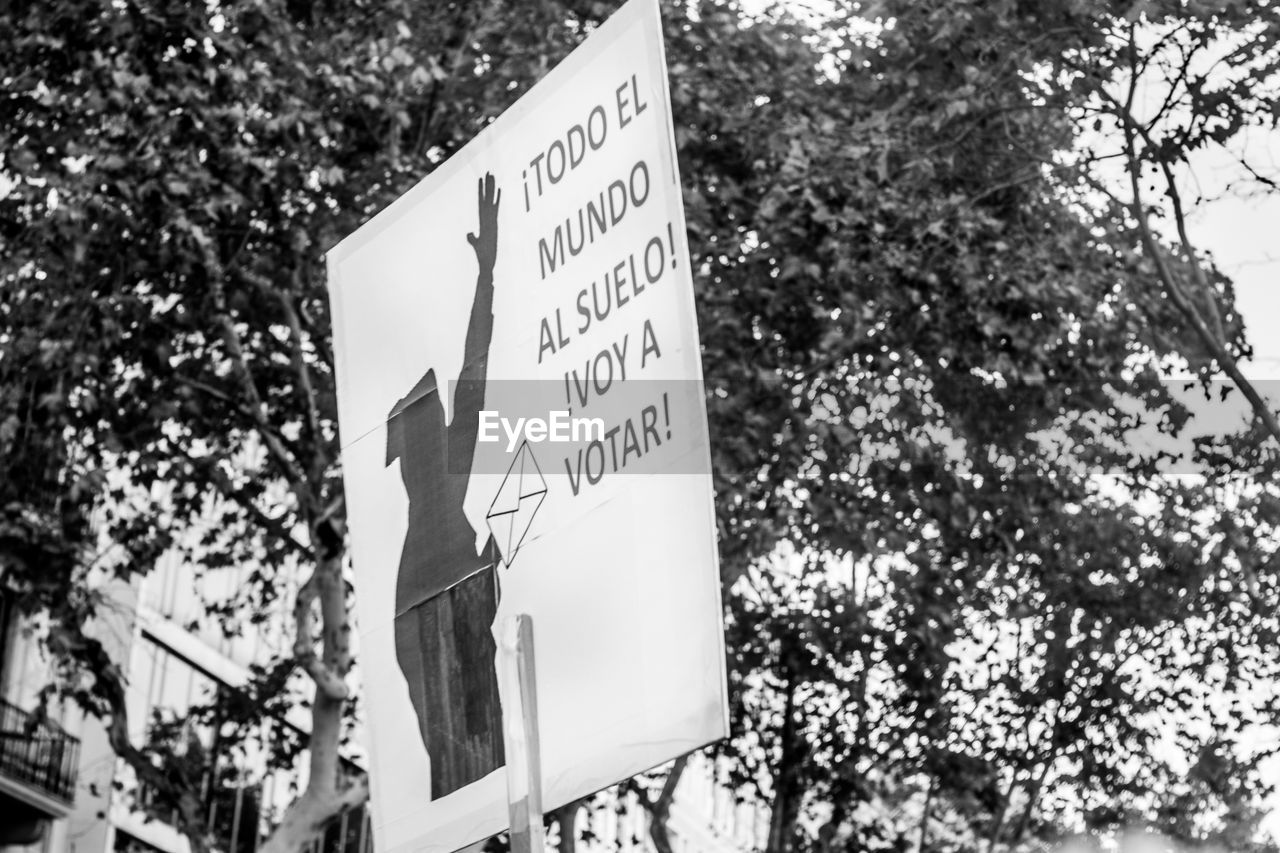 LOW ANGLE VIEW OF INFORMATION SIGN AGAINST TREE