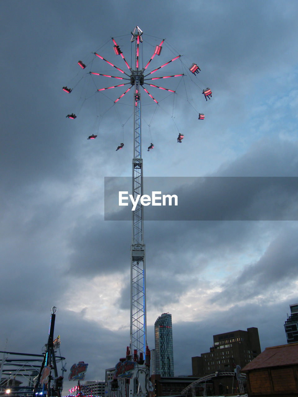 LOW ANGLE VIEW OF FERRIS WHEEL AGAINST SKY IN CITY