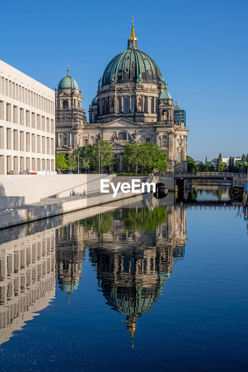 The berlin cathedral with the reconstructed city palace reflected in the river spree