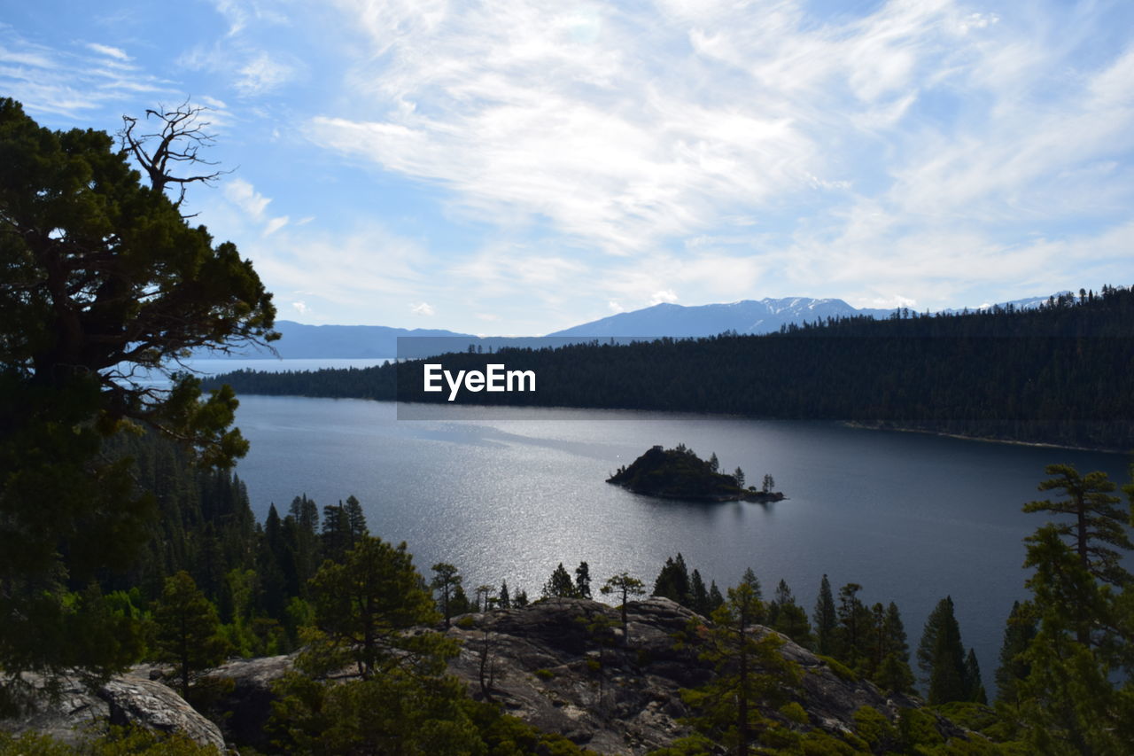 Scenic view of lake by trees against sky