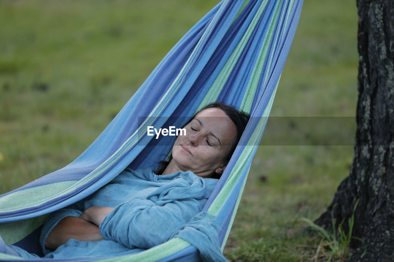 Portrait of woman lying on hammock