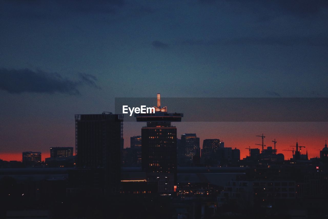 Illuminated cityscape against sky at night