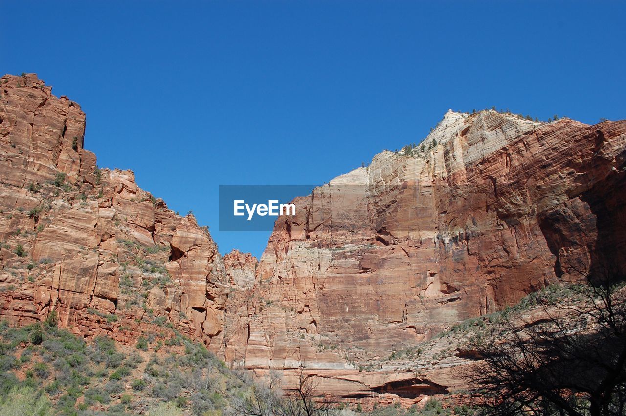 Rock formations against clear blue sky