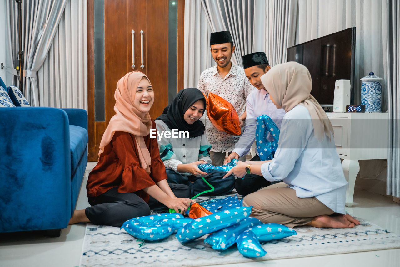 portrait of female friends using mobile phone while sitting on table