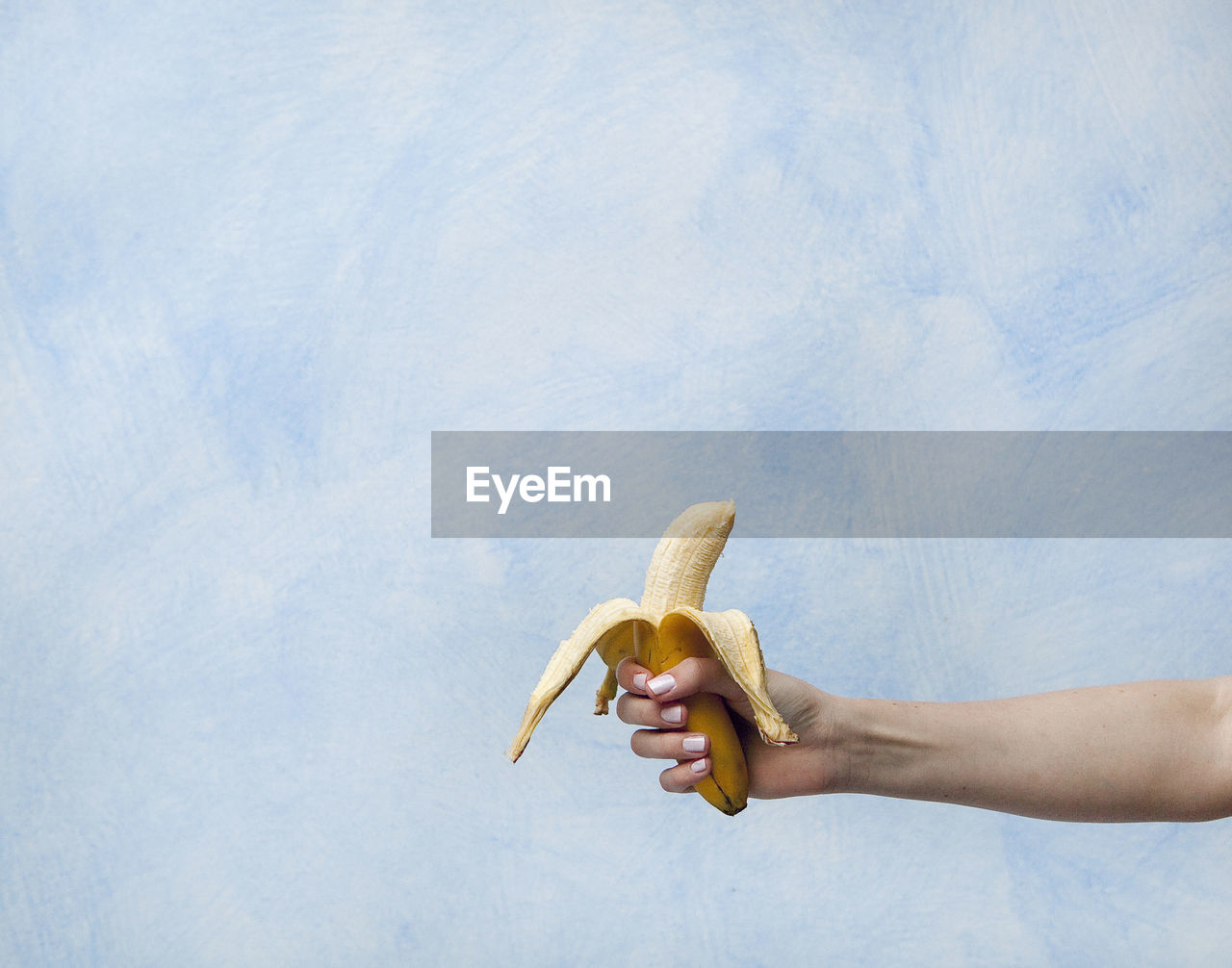 Close-up of man holding banana