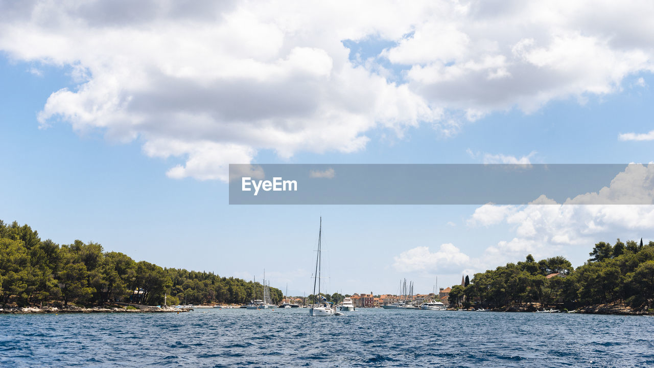 Sailboats sailing on sea against sky