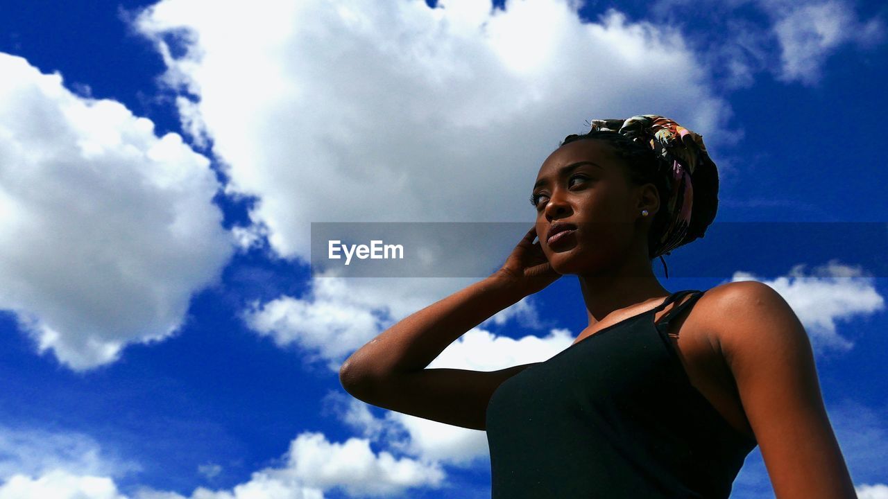 Low angle view of woman standing against sky