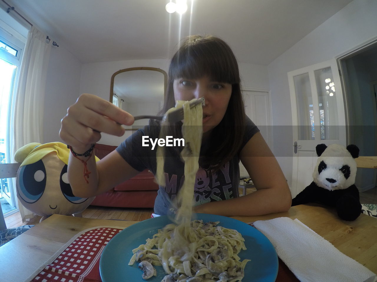 Beautiful woman eating pasta at home