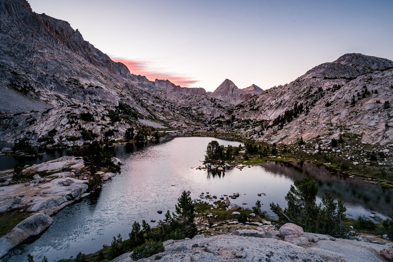 Scenic view of lake and mountains against sky during sunset