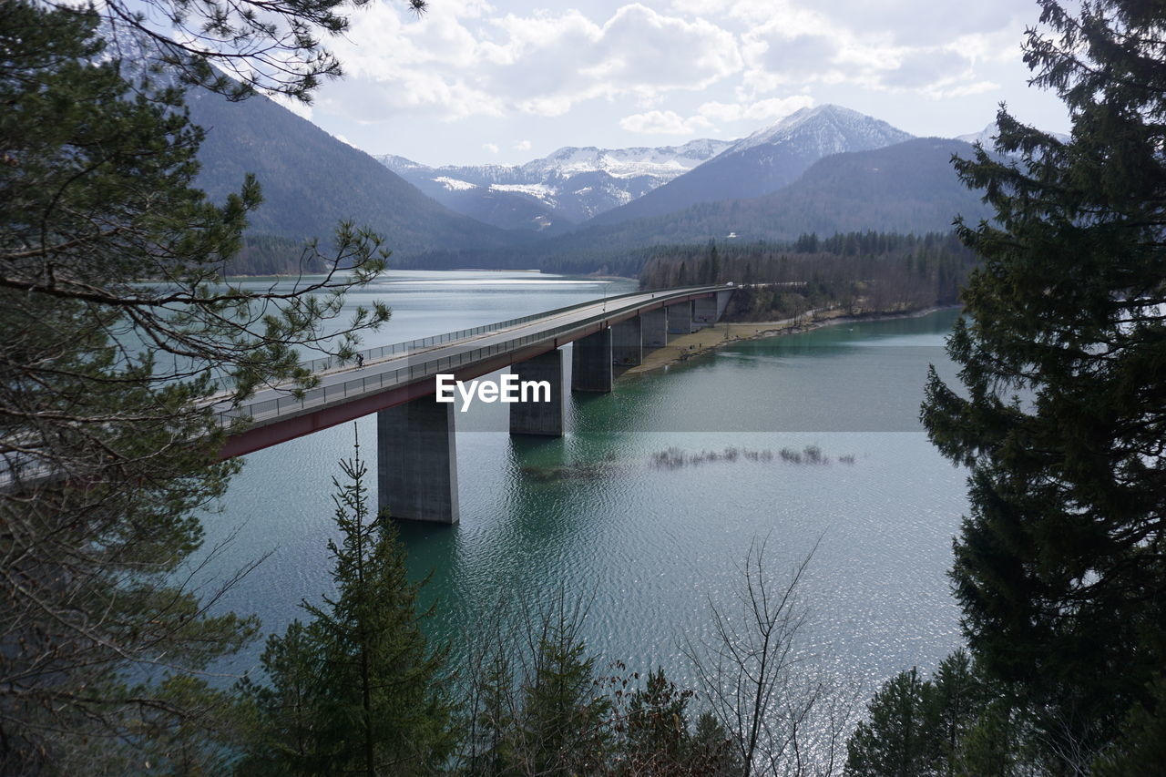 Scenic view of lake and mountains against sky with bridge