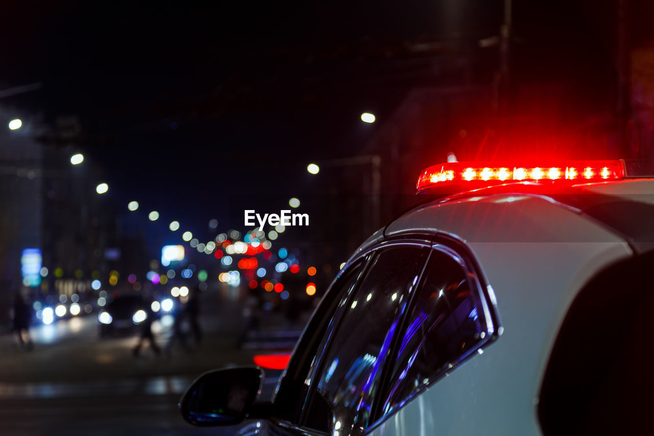 Police car lights in night city with selective focus and bokeh