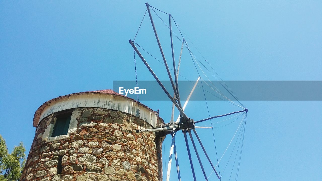 Low angle view of traditional windmill against sky