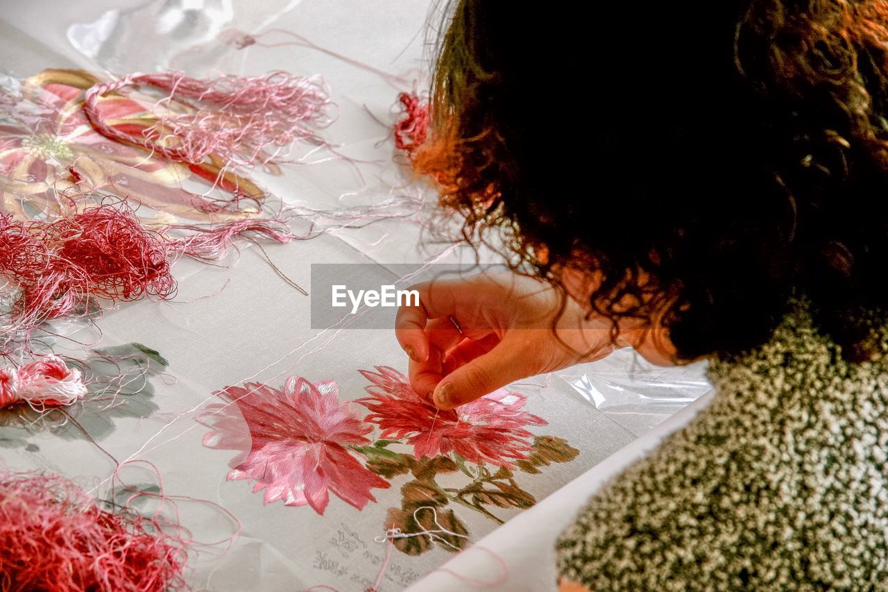 High angle view of woman making design on fabric