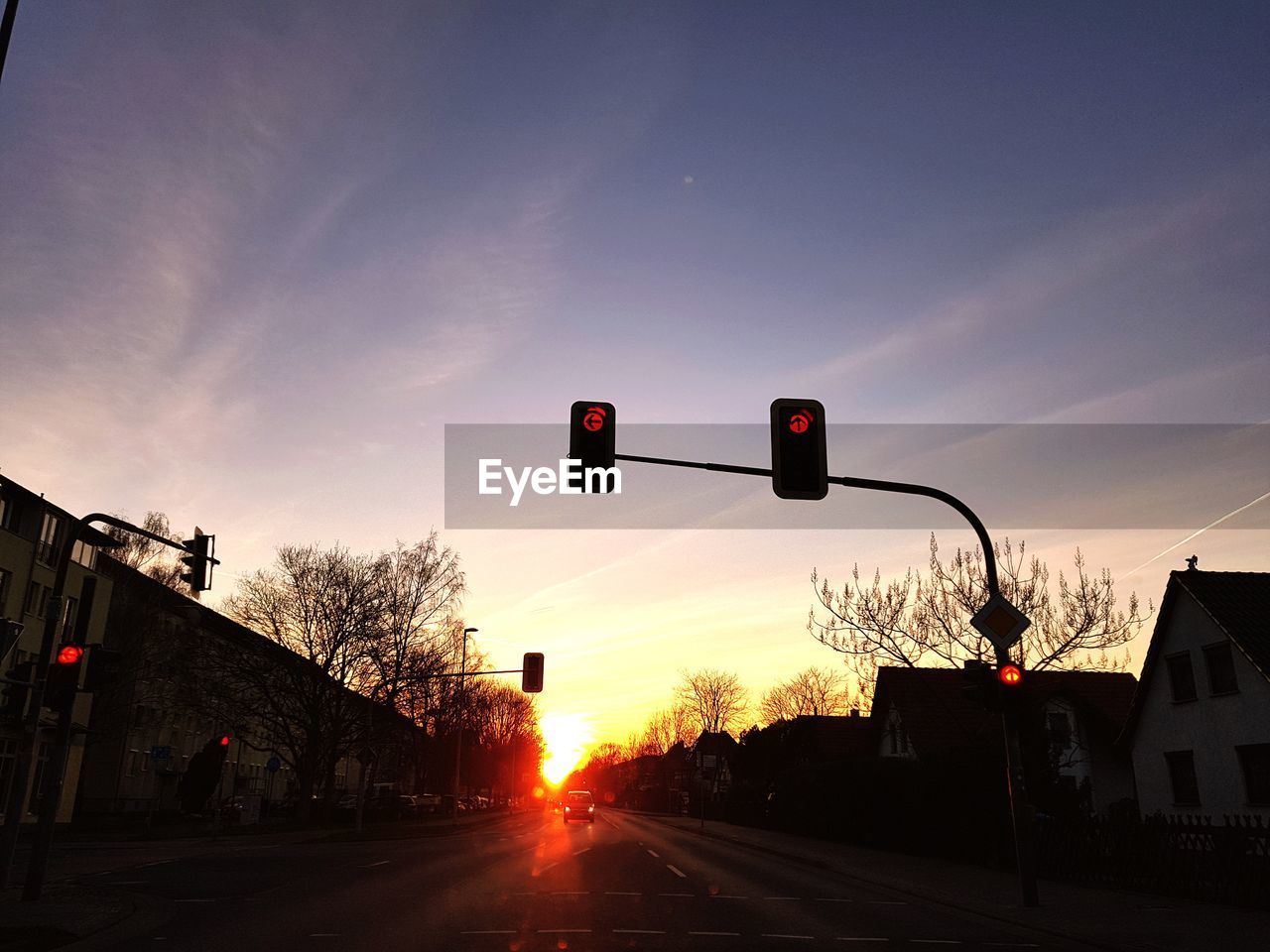 Road signal against sky during sunset