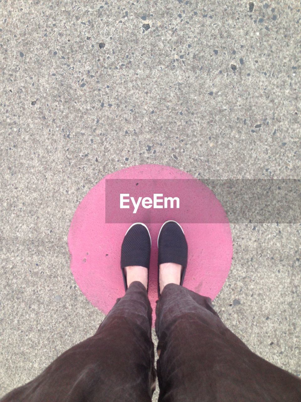 Low section of woman standing on pink built structure