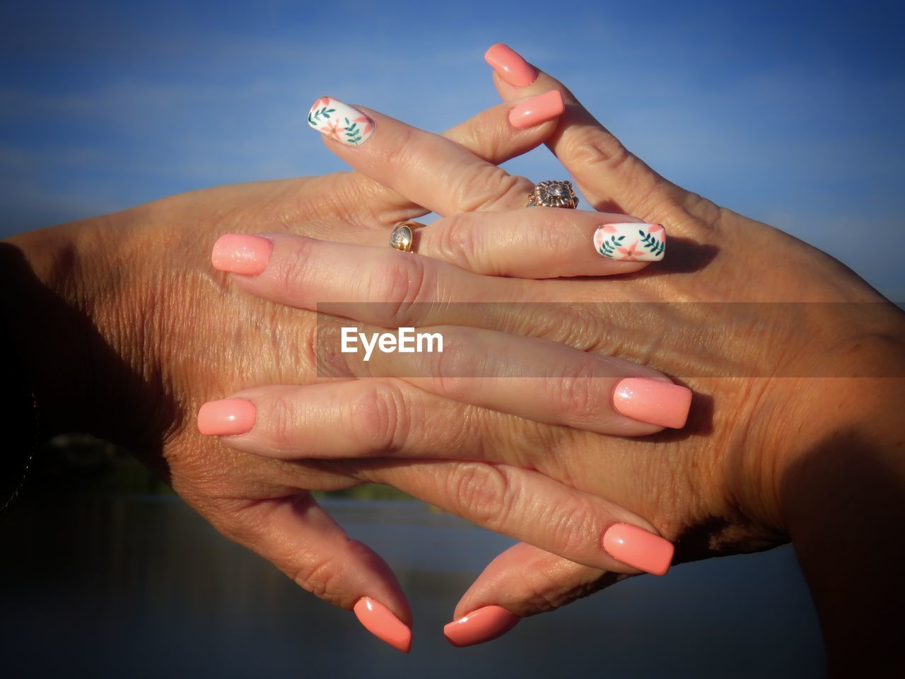 Cropped image of woman with hands clasped showing nail art