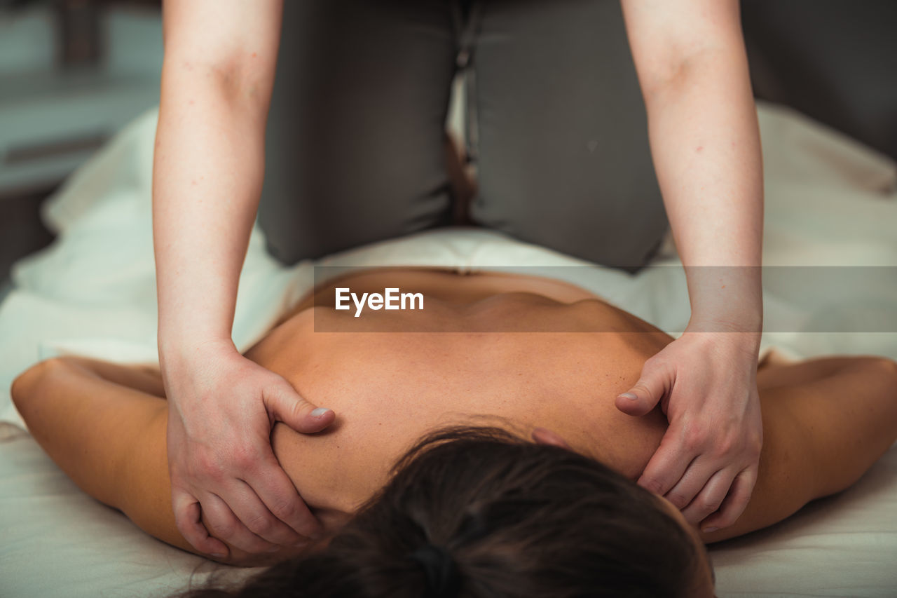 Relax massage for shoulders, hands of a massage therapist massaging shoulder of a female client